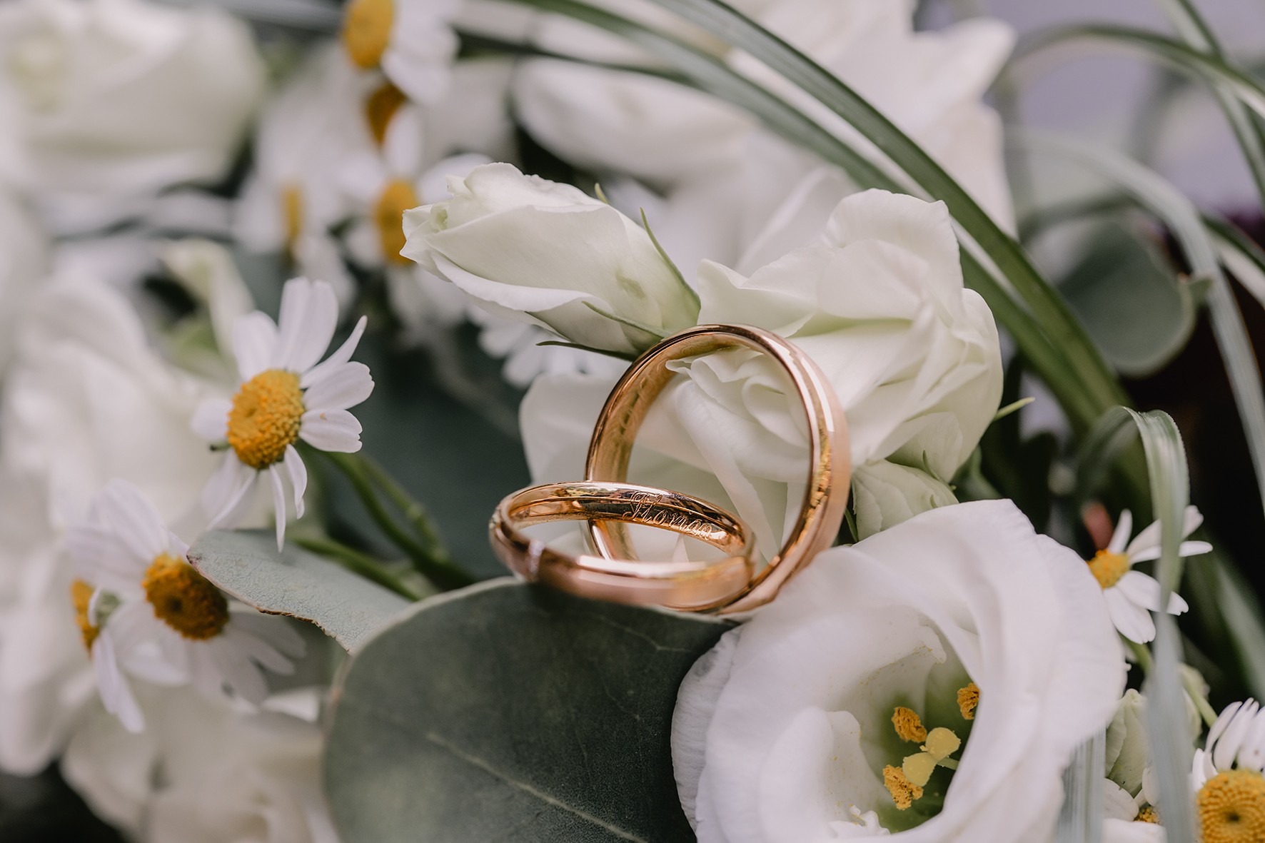 Eheringe auf weißen Blumen