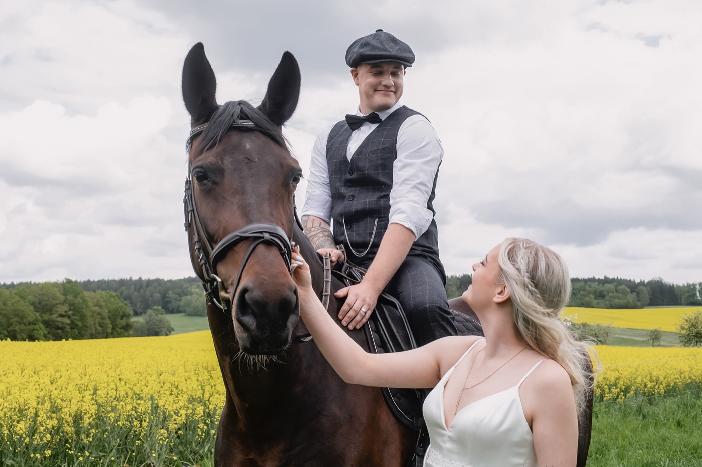 Nahaufnahme von Brautpaar und Pferd im Feld