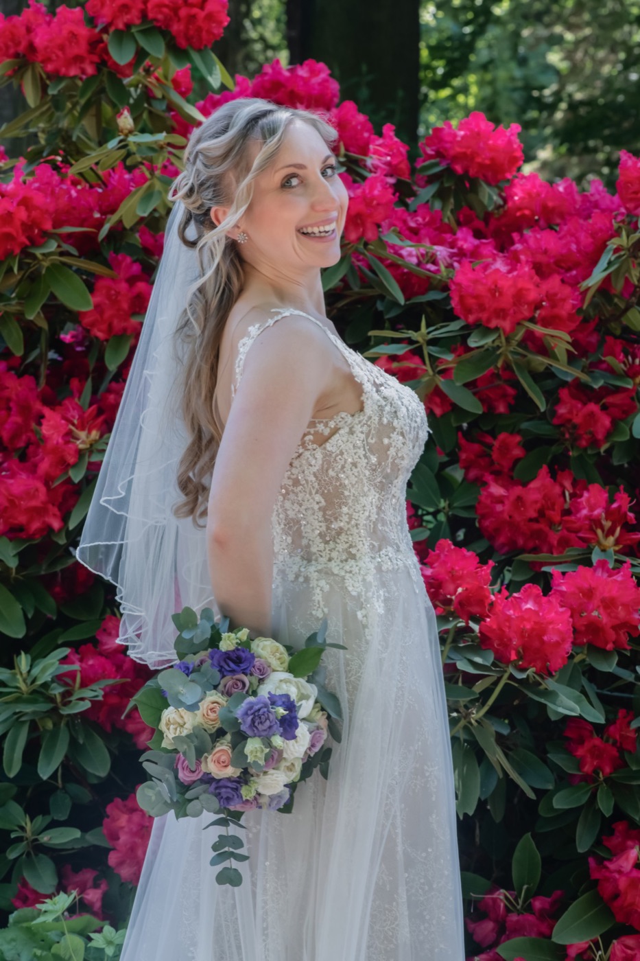 Detailaufnahme von Brautkleid und Strauß