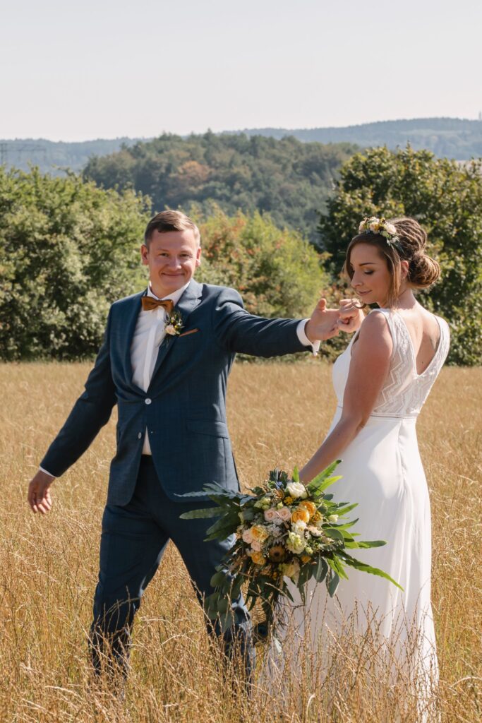 Brautpaar Hand in Hand im goldenen Feld
