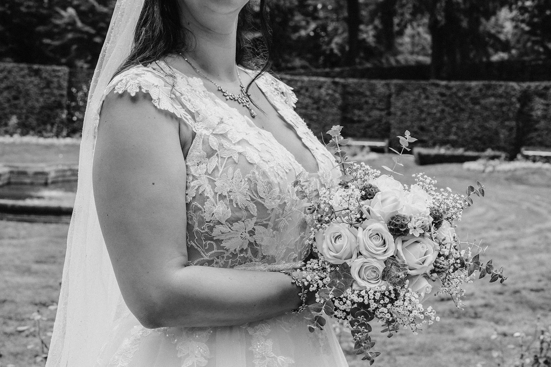 Detailaufnahme von Brautkleid und Blumenstrauß